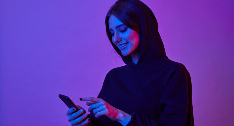 happy-young-woman-wearing-hoodie-using-smartphone-neon-lights-girl-surfing-internet-phone-pink-neon-light-780x420