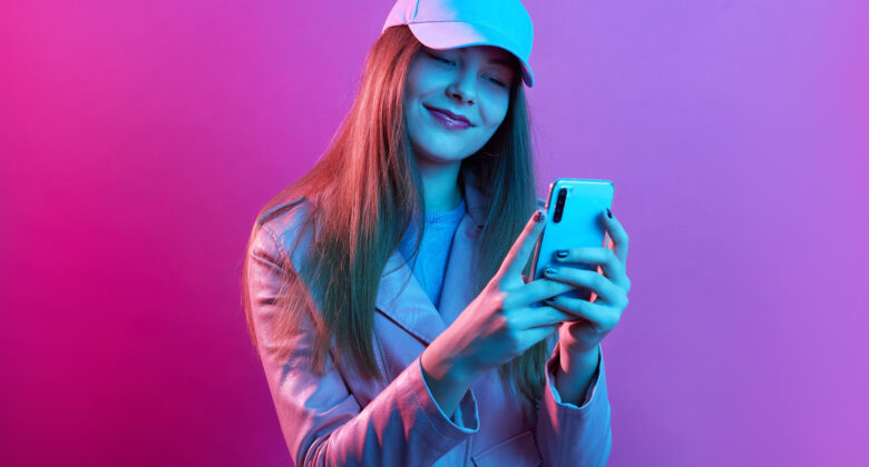 portrait-young-beautiful-fashionable-model-wearing-leather-baker-baseball-cap-holding-smart-phone-hands-780x420